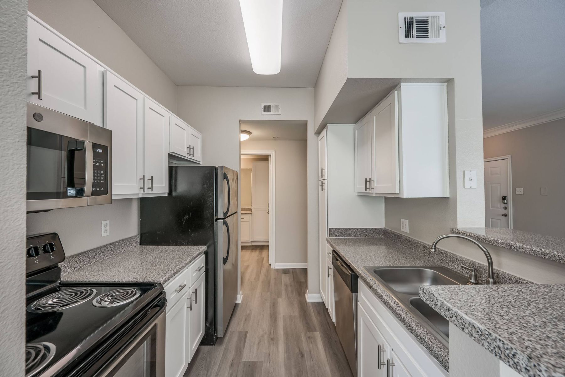 Luxury apartment kitchen with stainless steel appliances, granite countertops, and lots of storage space